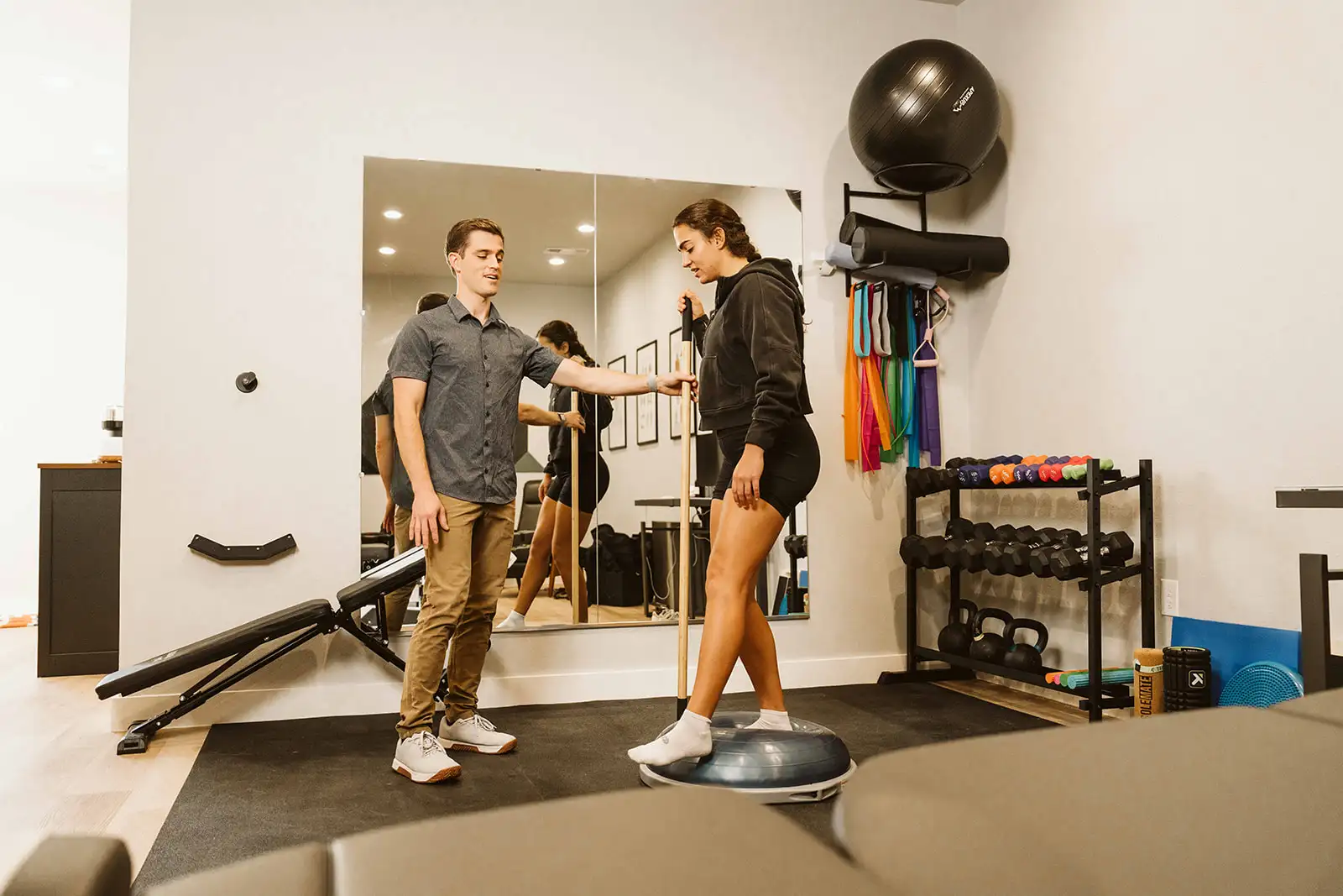 Dr. Hiebert guiding a patient during a balance exercise in the rehabilitation area