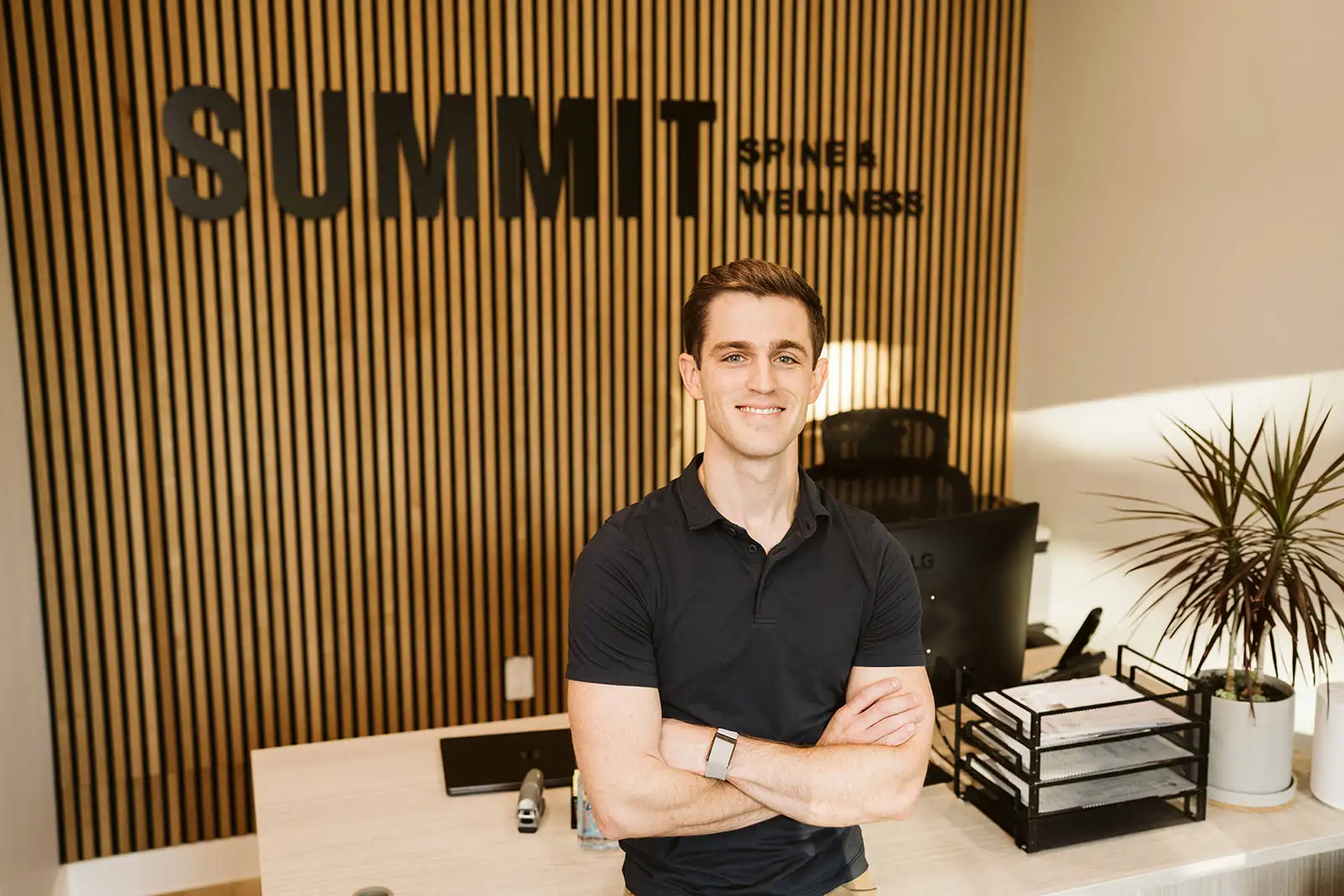 Dr. Spencer Hiebert in front of the Summit Spine & Wellness reception desk