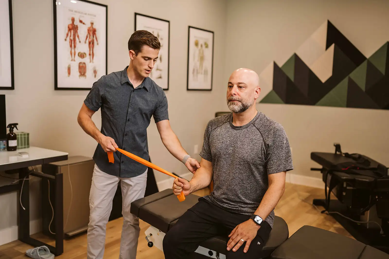 Dr. Hiebert guiding a patient through a resistance-band exercise at Summit Spine & Wellness